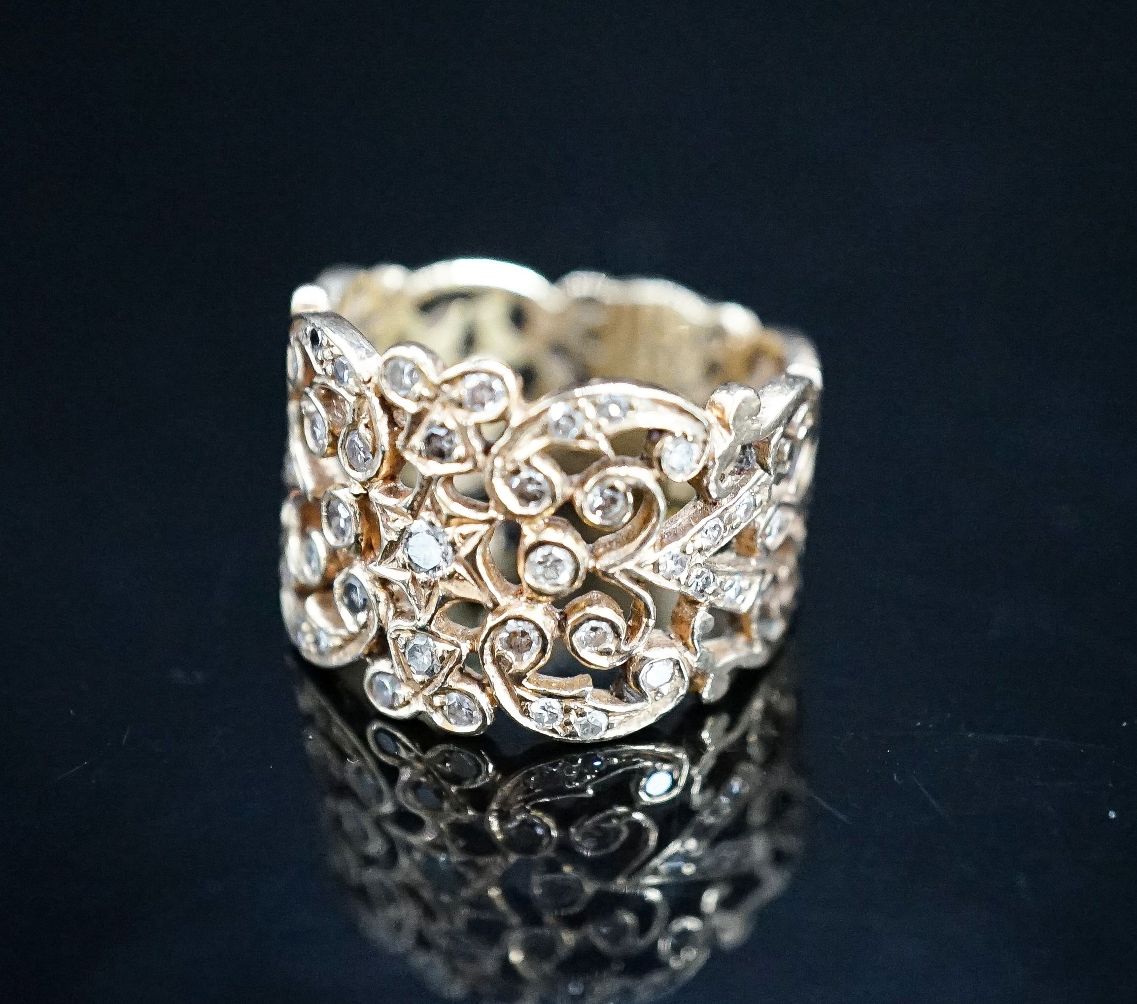 A continental pierced 14k and diamond chip set band, size L/M, gross weight 8.2 grams.